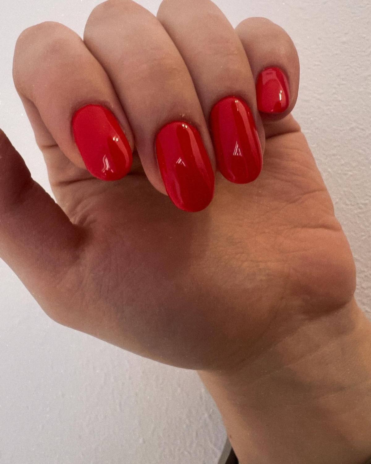 Kurze ovale Nägel in glänzendem Rot